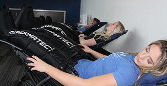 Three customers relaxing back with Normatec Compression Sleeves